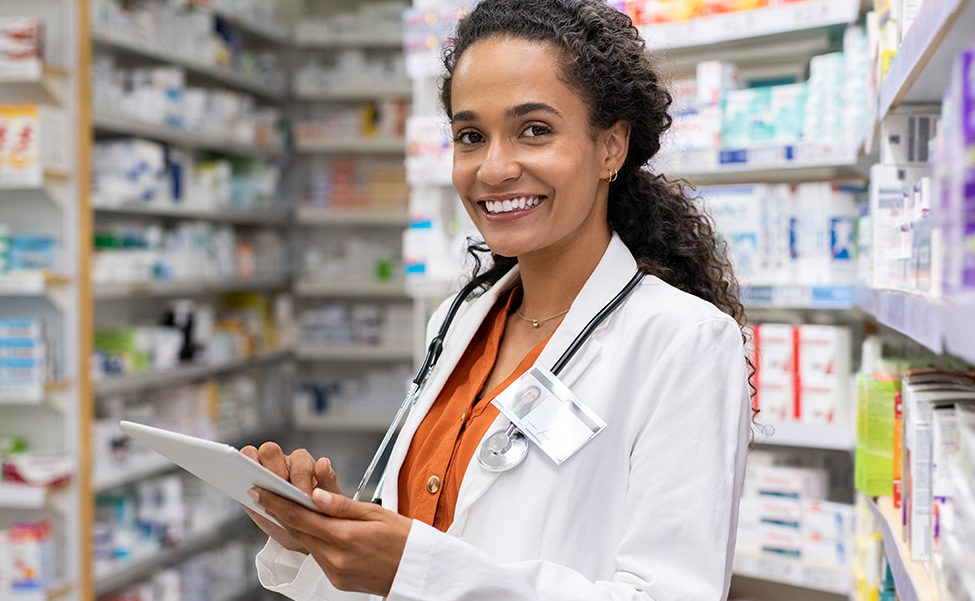 Pharmacist standing with a digital tablet, smiling